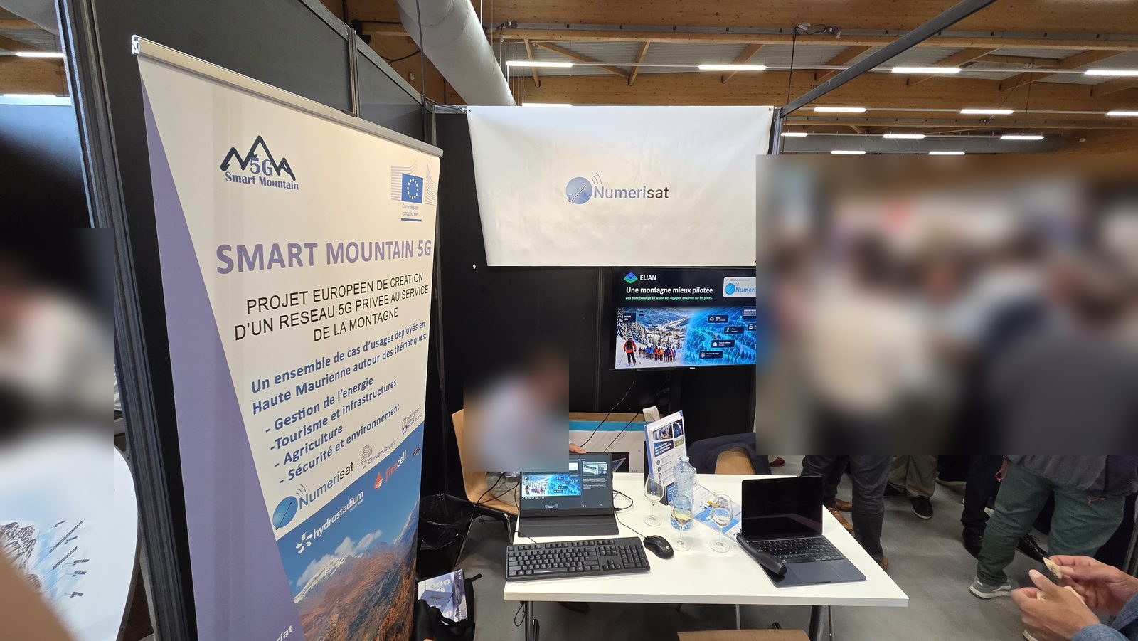 The Smart Mountain 5G banner, a European project building a private 5G network for the mountains, next to the ELIAN demo on the Numerisat stand.